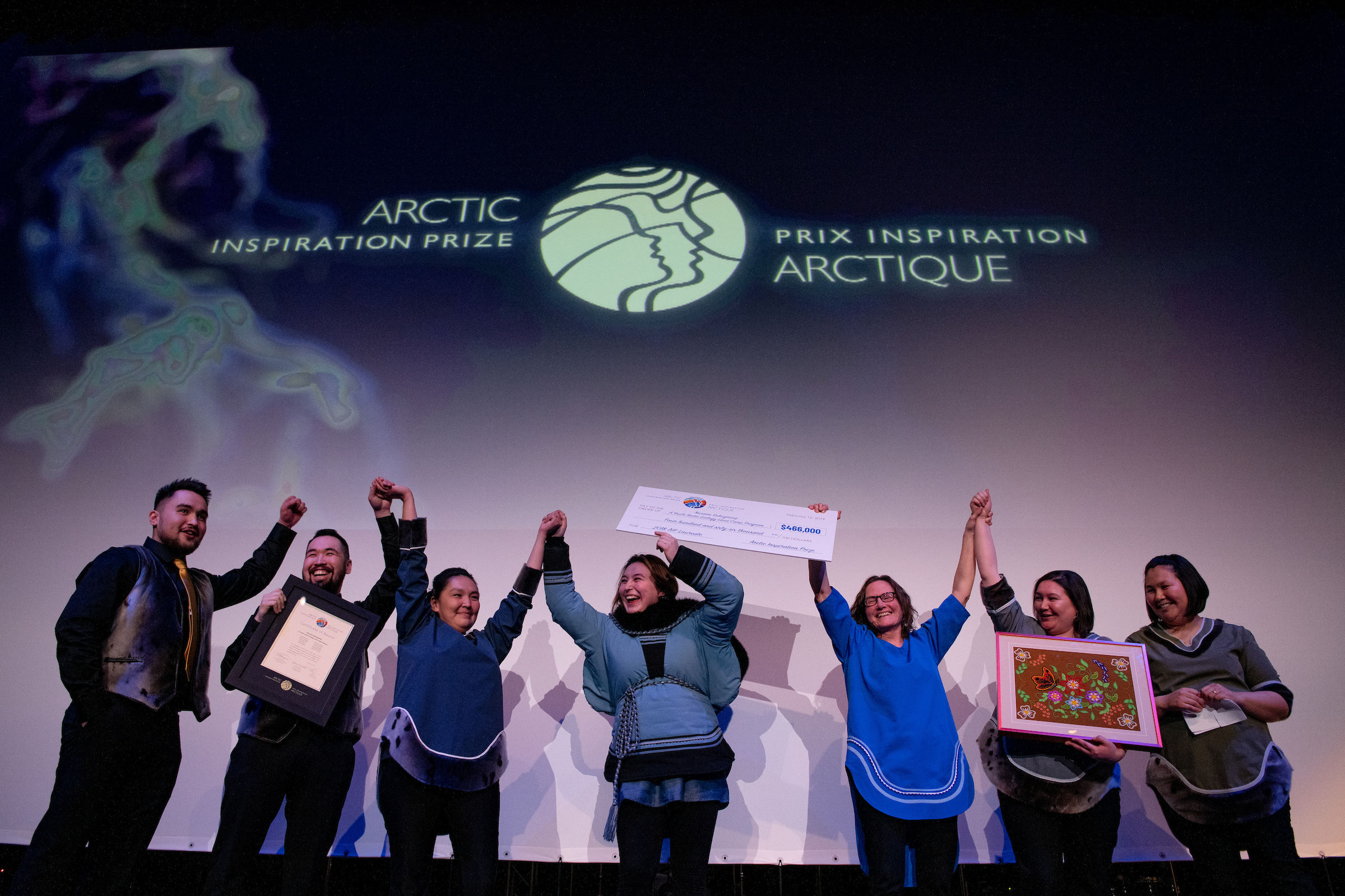 AIP Laureates celebrate their win on stage with a giant cheque.